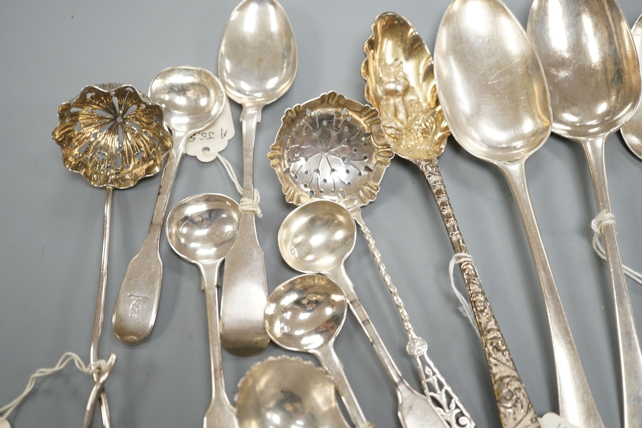 A small collection of 18th century and later silver flatware, including a table spoon by Thomas Eustace, Exeter, 1785, two 18th century silver lace back dessert spoons, an 18th century 'berry' spoon, a George III silver